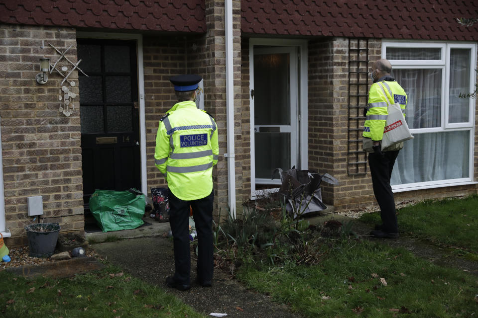 Police volunteers use large bags to collect completed COVID-19 home testing kits that residents received earlier in the day, in Woking, England, Tuesday, Feb. 2, 2021, during England's third national lockdown since the coronavirus outbreak began. British health authorities plan to test tens of thousands of people in a handful of areas of England in an attempt to stop a new variant of the coronavirus first identified in South Africa spreading in the community. The Department of Health says a small number of people in England who had not travelled abroad have tested positive for the strain. (AP Photo/Matt Dunham)