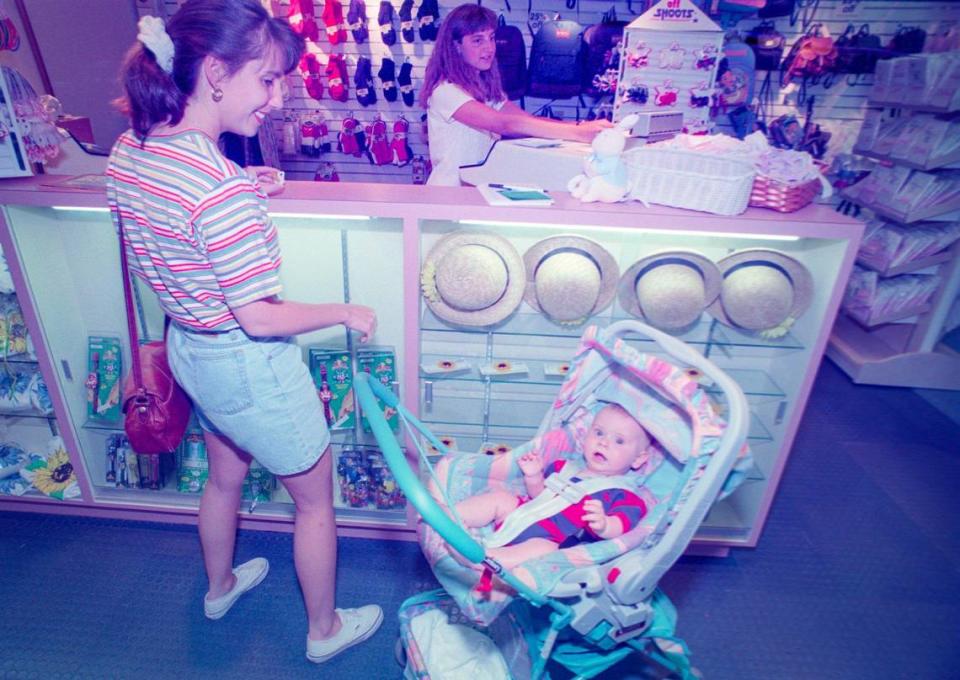 Melanie Meinerts rings up the purchases of Lauren Niezen and son Jake, 5 months, at the relocated Gottschalks Kids in the Central Coast Plaza on June 13, 1995.
