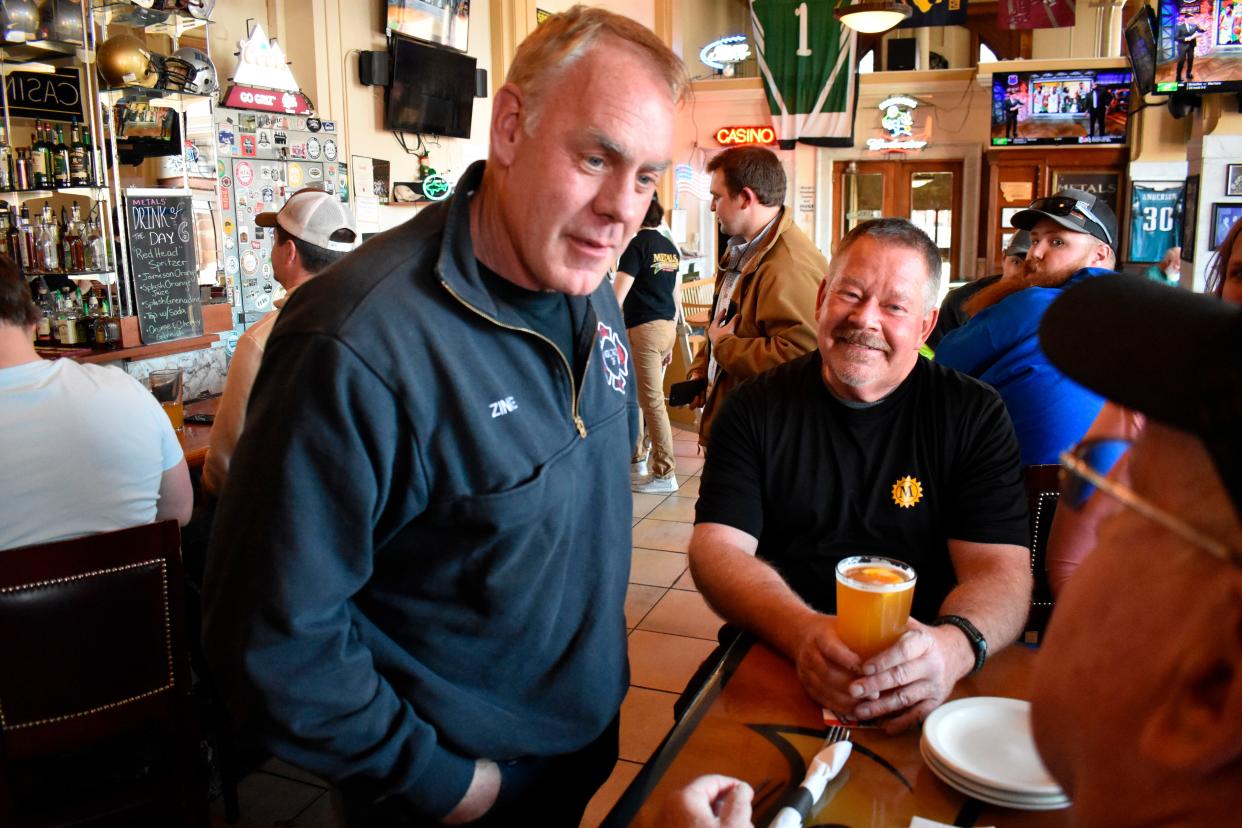 Montana U.S. House candidate and former Secretary of Interior Ryan Zinke, left, speaks with patrons at Metals Sports Bar and Grill, May 13, 2022, in Butte, Mont. Zinke is seeking election to a newly created U.S. House district. 