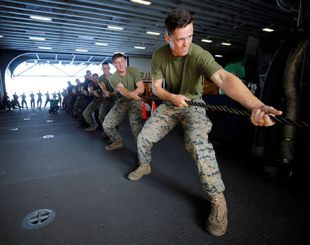 Marines aboard the USS Kearsarge haul a rope as the vessel secures lines with the supply ship USNS William McLean as it starts to refuel, resupply and take on humanitarian relief aid in the Caribbean Sea September 20, 2017. REUTERS/Jonathan Drake