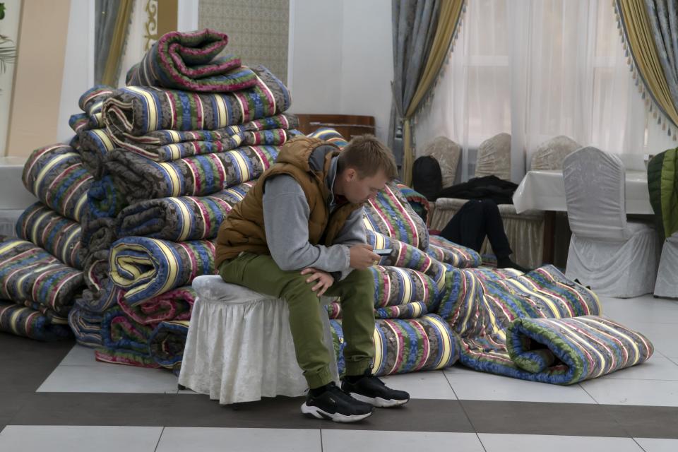 A Russian man rests in at temporary accommodation facility after crossing the border into Kazakhstan from the Mariinsky border crossing, about 400 km (250 miles) south of Chelyabinsk, in Russia, to Kazakhstan's town Ata-Meken, about 1400 km (250 miles) east of Astana, the capital of Kazakhstan, Wednesday, Sept. 28, 2022. Russians have crossed into Kazakhstan in the week since President Vladimir Putin announced a partial mobilization of reservists to fight in Ukraine, Kazakh officials said Tuesday, as men seeking to avoid the call-up continued to flee by land and air into neighboring countries. (AP Photo/Denis Spiridonov)