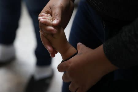 A woman holds a child's hand as undocumented immigrant families are released from detention at a bus depot in McAllen, Texas, U.S., June 22, 2018. REUTERS/Loren Elliott