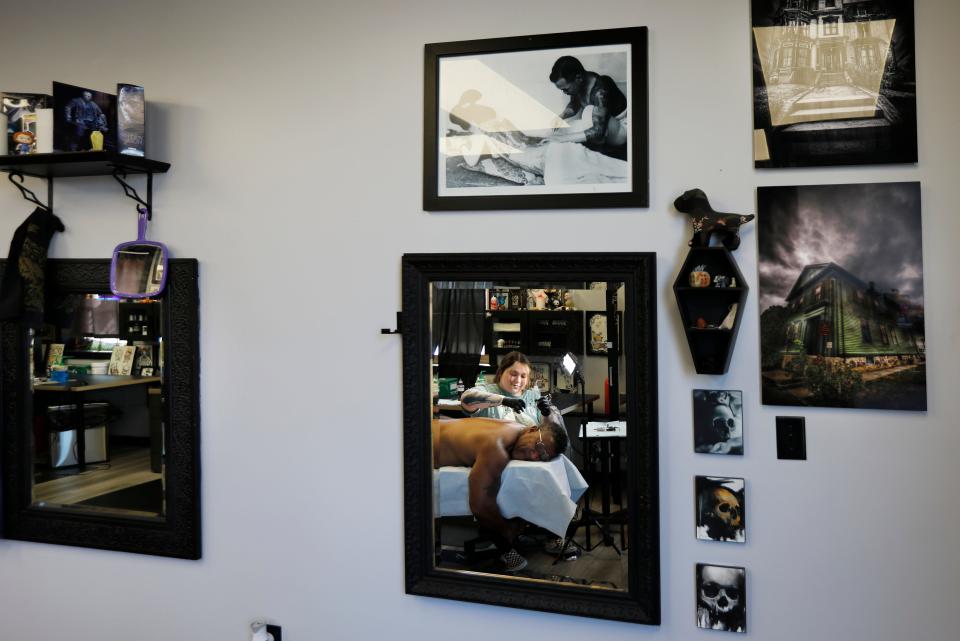 Rachel Garnett is reflected in the mirror hanging on the wall of the New Bedford Tattoo Co. as she gives Donald Tavares a new tattoo on his shoulder.
(Credit: PETER PEREIRA/The Standard-Times)