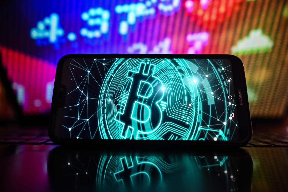 POLAND - 2023/02/01: In this photo illustration, a Bitcoin logo is displayed on a smartphone with stock market pricing in the background. (Photo Illustration by Omar Marques/SOPA Images/LightRocket via Getty Images)