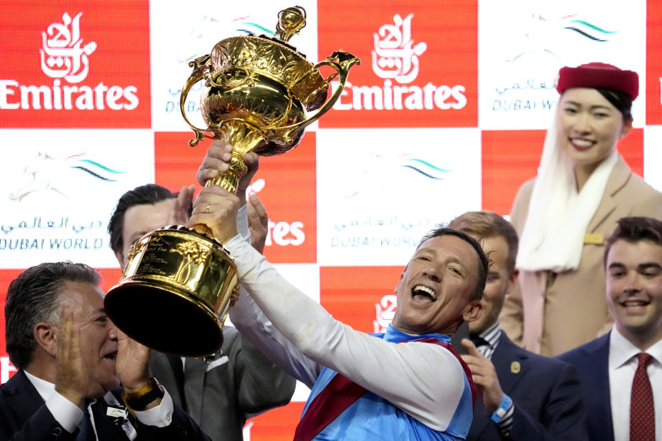Lanfraco Dettori, rider of Country Grammer holds the trophy after he won the Group 1 Dubai World Cup over 2000m (10 furlongs) at Meydan Racecourse in Dubai, United Arab Emirates, Saturday, March 26, 2022. (AP Photo/Ebrahim Noroozi)