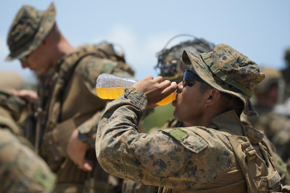 A U.S. marine drinks as he waits under the scorching sun at the airport of the Philippines' northernmost town of Itbayat, Batanes province during a joint military exercise on Monday, May 6, 2024. American and Filipino marines held annual combat-readiness exercises called Balikatan, Tagalog for shoulder-to-shoulder, in a show of allied military readiness in the Philippines' northernmost town facing southern Taiwan. (AP Photo/Aaron Favila)