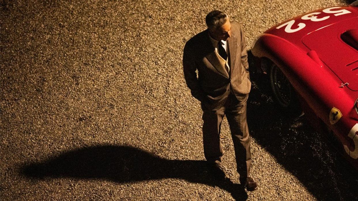 a man walking next to a red car