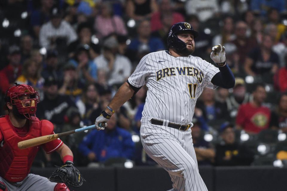Milwaukee Brewers' Rowdy Tellez, right, watches his double that brought in two runs during the first inning of a baseball game against the Cincinnati Reds, Sunday, Sept. 11, 2022, in Milwaukee. (AP Photo/Kenny Yoo)