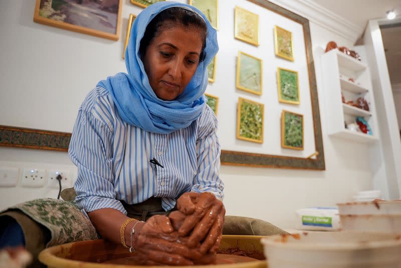 Awatif Al-Keneibit, a Saudi artist, moulds clay in her studio, in Riyadh