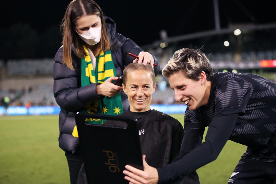 Aivi Luik, pictured here having her head shaved after the Matildas' win over New Zealand.