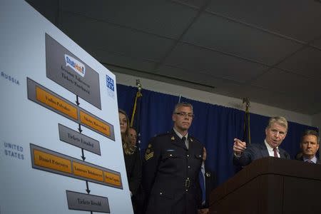 Manhattan District Attorney Cyrus Vance Jr. (2nd R) speaks during a news conference at his office as Sgt Richard Rollings (C) of the Royal Canadian Mounted Police and Special Agent Robert Sica (R) of the U.S. Secret Service look on, in midtown Manhattan, New York July 23, 2014. REUTERS/Brendan McDermid