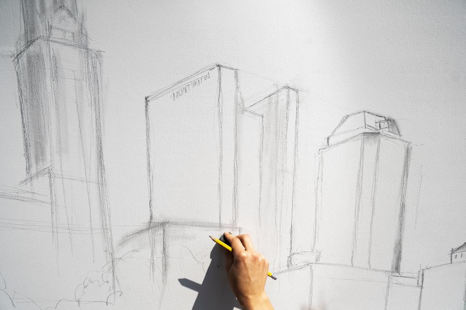 Bridgette Barnes works on her piece as part of the Scribble event Friday at the Columbus Arts Festival in downtown Columbus. Barnes, 29, of Victorian Village, is painting Columbus buildings in a way that will demonstrate the coexistence of nature and industry in the city.