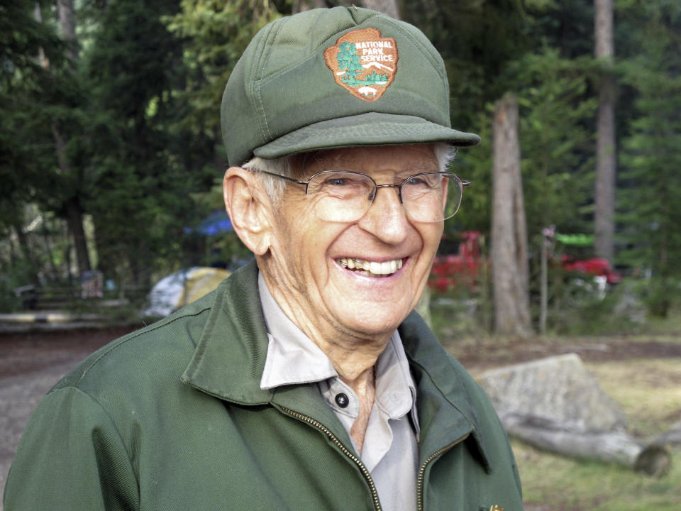 This Sept. 6, 2013 photo shows Lyle Ruterbories smiling as he speaks with a visitor to the Kintla Lake Campground in Glacier National Park, Mont. Ruterbories is the National Park Service's oldest ranger at age 93. He and his wife Marge managed the campground since 1991, and Ruterbories has continued on his own since her death in 2005. (AP Photo/Matt Volz)