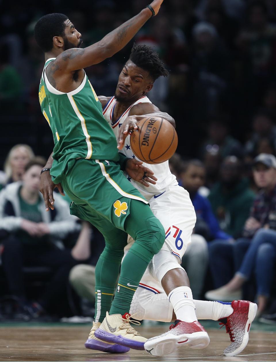 Philadelphia 76ers' Jimmy Butler, right, fouls Boston Celtics' Kyrie Irving during the first half of an NBA basketball game in Boston, Tuesday, Dec. 25, 2018. (AP Photo/Michael Dwyer)