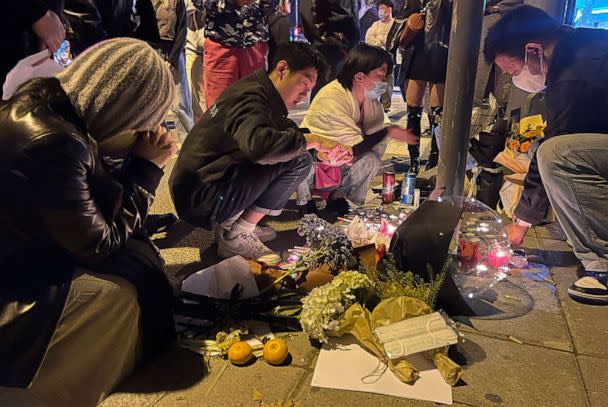 PHOTO: People visit a memorial for victims of a recent deadly fire at a residential building in Urumqi city at a road sign on Middle Urumqi Rd., Nov. 26, 2022, in Shanghai. (AP Photo)