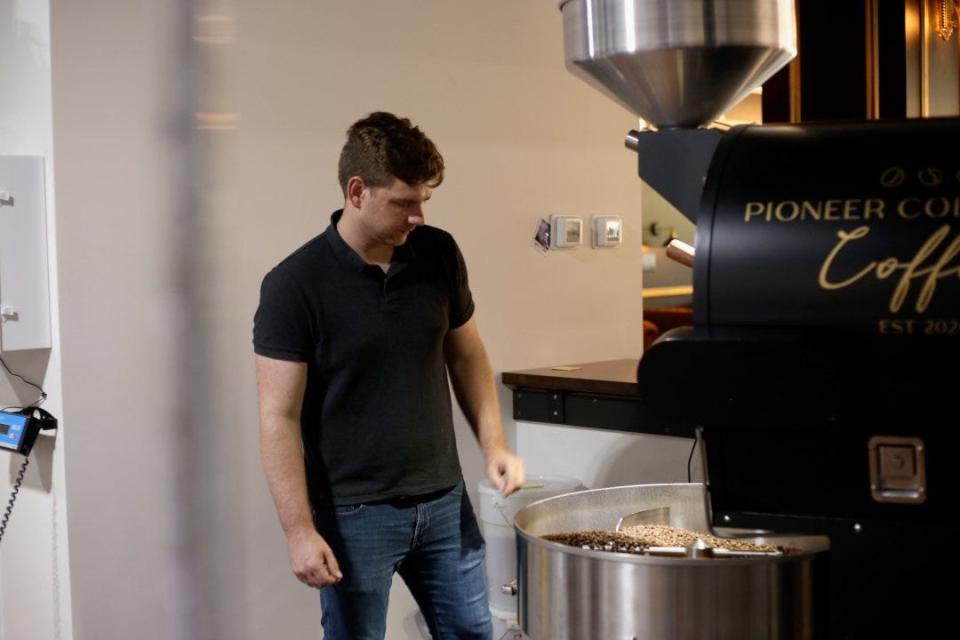 Owner and roaster Andrew Keim stands in front of the Diedrich roaster at Pioneer Coffee Co.