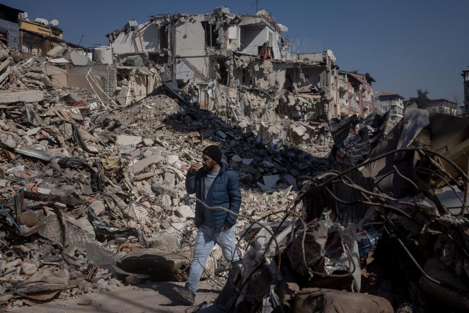 A man walks amid the rubble of destroyed buildings on Feb. 15, 2023, in Hatay, Turkey. A 7.8-magnitude earthquake hit near Gaziantep, Turkey, in the early hours of February 6, followed by another 7.5-magnitude tremor just after midday. The quakes caused widespread destruction in southern Turkey and northern Syria and killed more than 30,000 people.