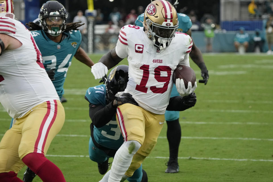 San Francisco 49ers wide receiver Deebo Samuel (19) breaks a tackle by Jacksonville Jaguars cornerback Darious Williams (31) to score a touchdown during the second half of an NFL football game, Sunday, Nov. 12, 2023, in Jacksonville, Fla. (AP Photo/John Raoux)