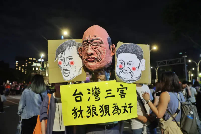 ▲周邊抗議人潮中，有人手持「台灣三害」標語，諷刺韓國瑜、傅崐萁、黃國昌。（圖／記者陳明中攝）