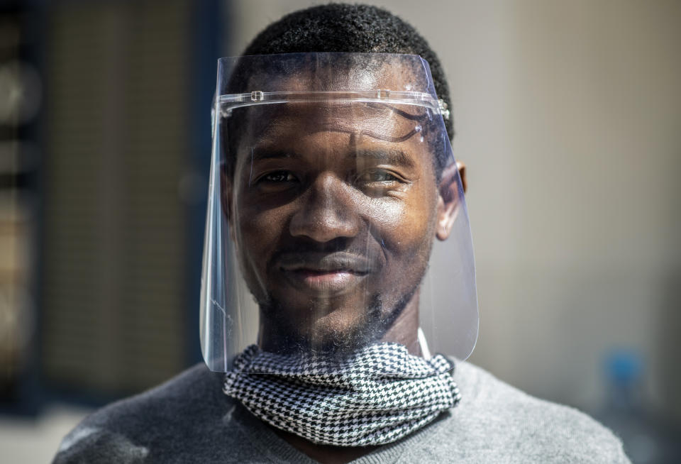 In this photo taken Thursday, April 16, 2020, Idrissa Sall demonstrates a protective face shield made with a laser cutter, to be used to protect against transmission of the coronavirus, at the FabLab workshop at the Ker Thiossane multimedia center in Dakar, Senegal. Researchers across Africa are looking for ways to make their own ventilators, protective equipment and hand sanitizers as the continent faces a peak in coronavirus cases long after the United States and European countries have bought up global supplies during the pandemic. (AP Photo/Sylvain Cherkaoui)