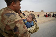 A member from a Shi'ite paramilitary group called the Abbas Division carries a sick and displaced boy who fled from his home with his family during a battle with Islamic State militants on the outskirts of Badush, Iraq, March 13, 2017. REUTERS/Stringer