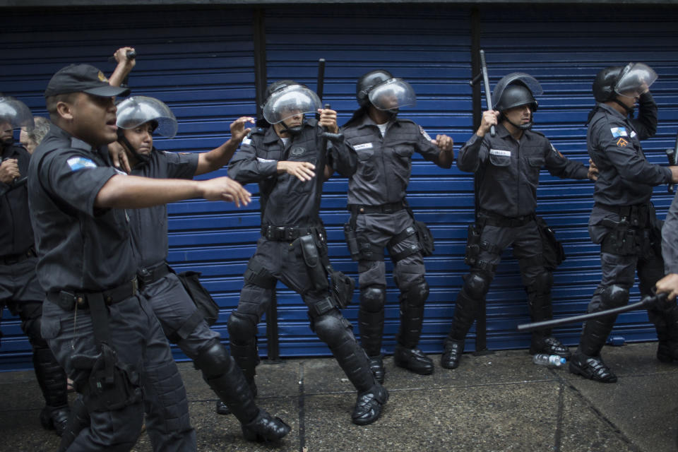 Police officers clash with residents of Pavao Pavaozinho slum during a protest against the death of Douglas Rafael da Silva Pereira after his burial, in Rio de Janeiro, Brazil, Thursday, April 24, 2014. The protest followed the burial of Pereira, whose shooting death sparked clashes Tuesday night between police and residents of the Pavao-Pavaozinho slum. (AP Photo/Felipe Dana)