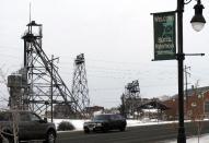 In this Dec. 14, 2016, photo old mining headframes dominate the skyline of Butte, Mont. Residents of the Montana mining city of Butte say the deaths of more than 3,000 snow geese should be a wake-up call for the future of a former open pit mine that is filled with 50 billion gallons of acidic, metal-laden water. (AP Photo/Matt Volz)