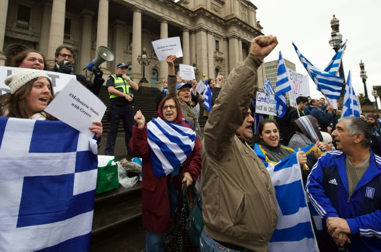 Protesters wave the Greek flag as they shout "Oxi" (No) during the "Melbourne stands with Greece" solidarity rally outside Parliament House in Melbourne on July 4, 2015