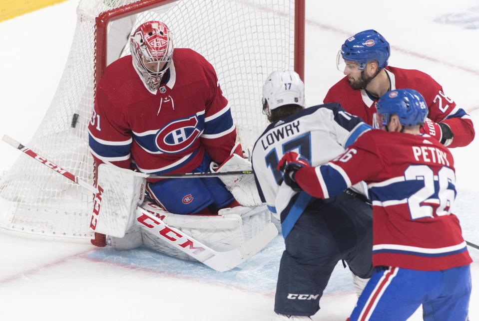 Winnipeg Jets' Adam Lowry (17) shoots against Montreal Canadiens goaltender Carey Price, left, as Canadiens' Marco Scandella (28) and Jeff Petry (26) defend during second-period NHL hockey game action in Montreal, Monday, Jan. 6, 2020. (Graham Hughes/The Canadian Press via AP)