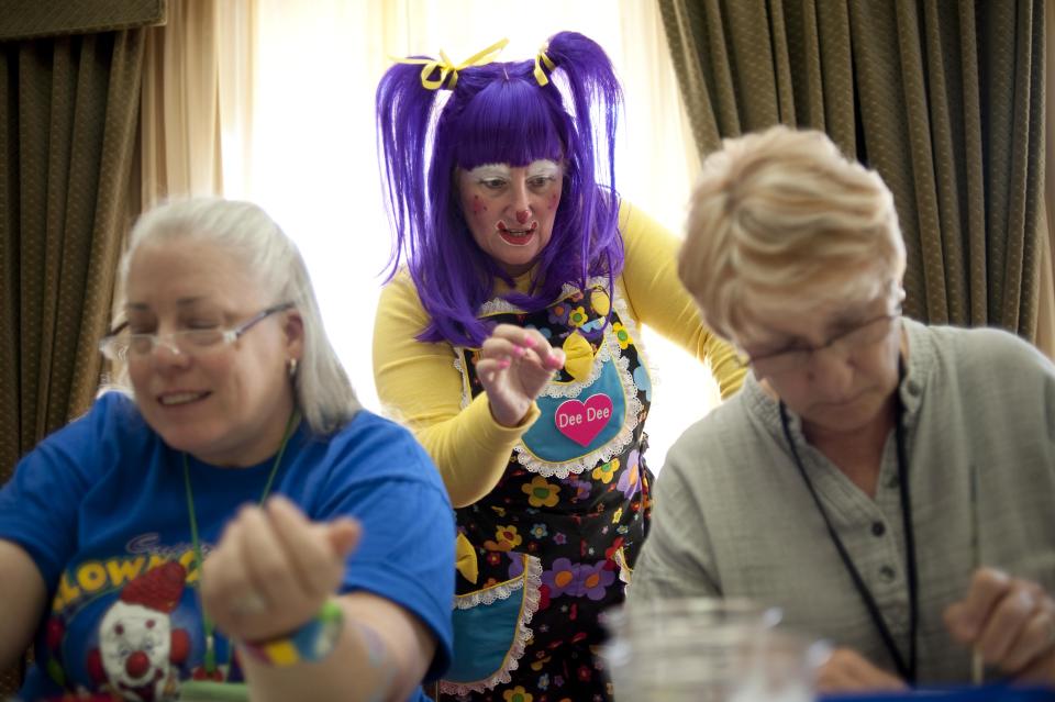 In a July 31, 2012 photo, Deanna Hartmier, aka "Dee Dee" the clown, center, offers tips to Patricia Jannell, aka "PJ" the clown, and Carol Feldhelm, aka "Dizzy Daizy" the clown, during a face painting class at the third annual Clown Campin' in Ontario, Calif. The week long event is held for clowns across the United States and Canada to learn, get inspired, and network. (AP Photo/Grant Hindsley)