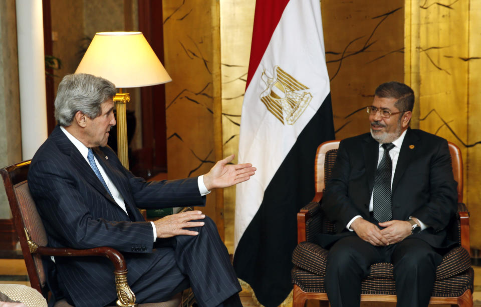 FILE - In this May 25, 2013 file photo, U.S. Secretary of State John Kerry, left, meets with Egyptian President Mohammed Morsi in Addis Ababa, Ethiopia. On Monday June 17, 2019, Egypt's state TV said the country's ousted President Mohammed Morsi, 67, collapsed during a court session and died. It said it occurred while he was attending a court trial on Monday on espionage charges. Morsi, who hailed from Egypt's largest Islamist group, the now outlawed Muslim Brotherhood, was elected president in 2012 in the country's first free elections following the ouster the year before of longtime leader Hosni Mubarak. (AP Photo/Jim Young, Pool, File)
