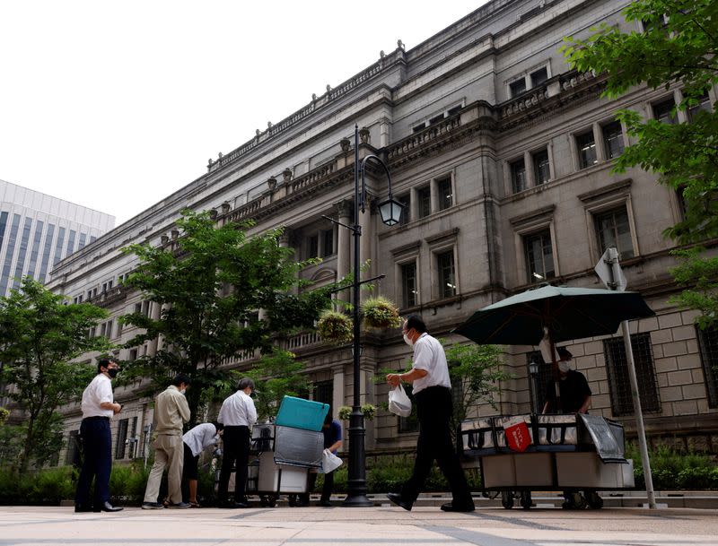 FILE PHOTO: People buy their lunches from street vendors in front of the headquarters of Bank of Japan in Tokyo