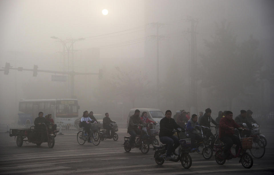 Residents ride bicycles along a street amid dense smog&nbsp;in Xingtai, China.