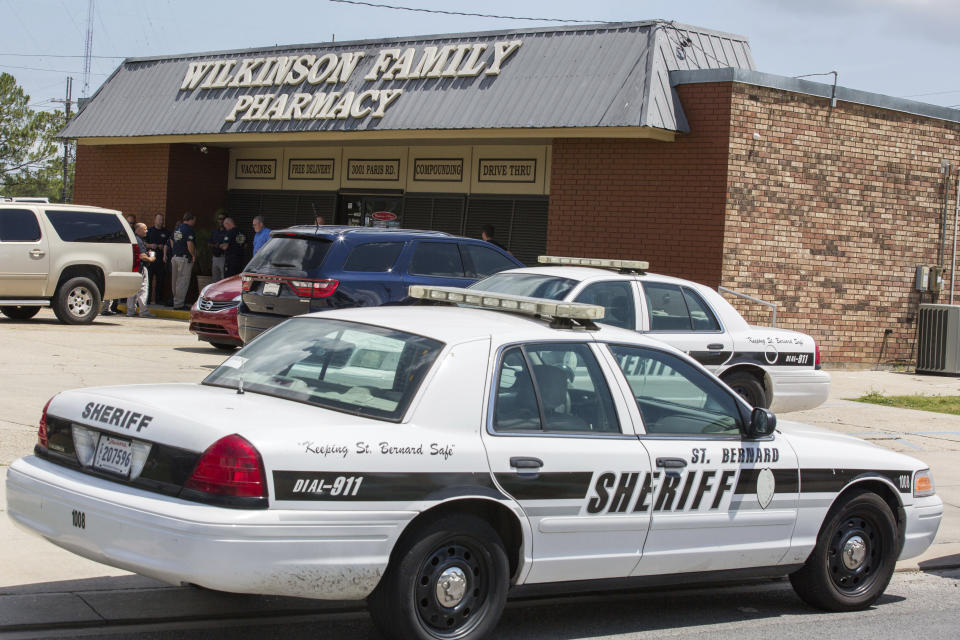 Accompanied by local law enforcement, U.S. Drug Enforcement Administration agents raid Wilkinson Family Pharmacy in Chalmette, La., Wednesday, April 19, 2017. Wilkinson purchased more than 4.5 million pills of oxycodone and hydrocodone from Morris & Dickson between 2014 and 2017, and federal prosecutors say during that time owner Keith Wilkinson laundered more than $345,000 from illegal opioid sales made with forged prescriptions or written by “pill mill” doctors. (Sophia Germer/The Advocate via AP)