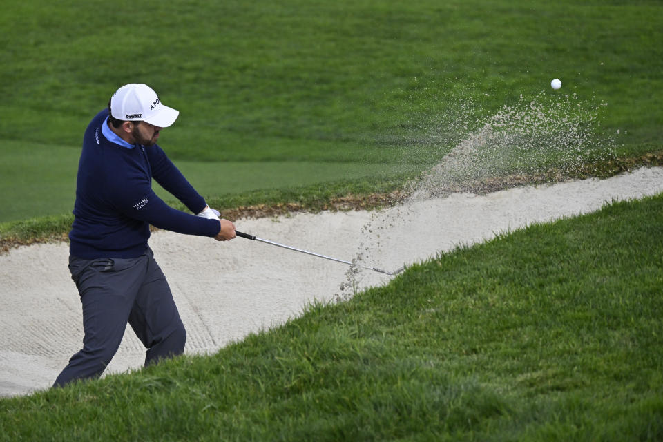 Patrick Cantlay hits out of the bunker on the 18th hole of the North Course at Torrey Pines during the first round of the Farmers Insurance Open golf tournament Wednesday, Jan. 24, 2024, in San Diego. (AP Photo/Denis Poroy)