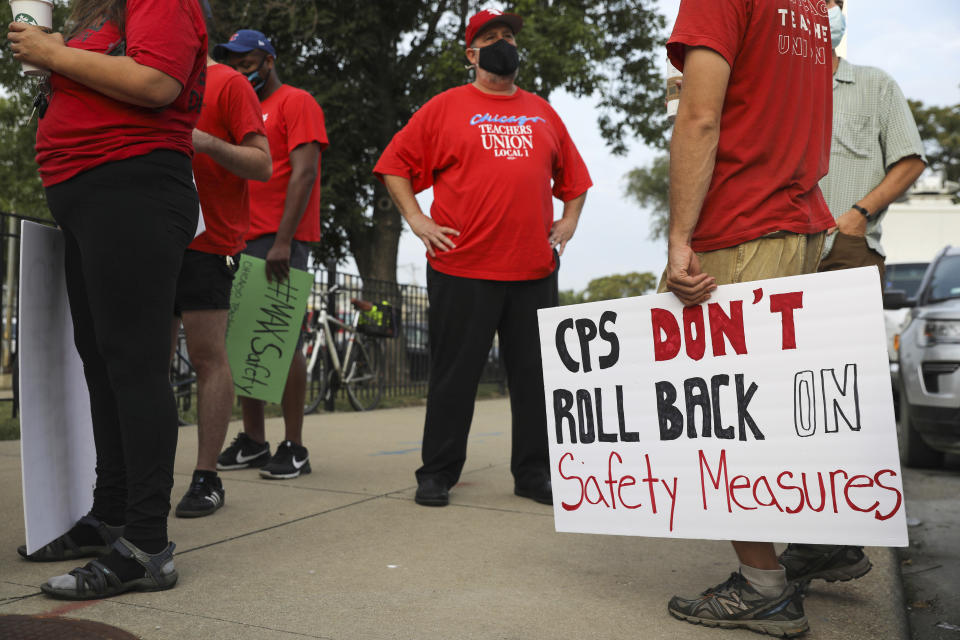 Chicago Teachers Union members gather outside Benito Juarez Community Academy to discuss safety for students and staff in Chicago, Wednesday, Aug. 18, 2021. The Chicago Teachers Union and the city's school district are at "an impasse” in talks over COVID-19 safety protocols ahead of school starting at the end of the month, the union's leader said Wednesday. (Jose M. Osorio/Chicago Tribune via AP)