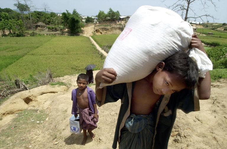 Rohingya refugee boys carry food at Kutupalong refugee camp near Cox's Bazar, on April 20, 2002