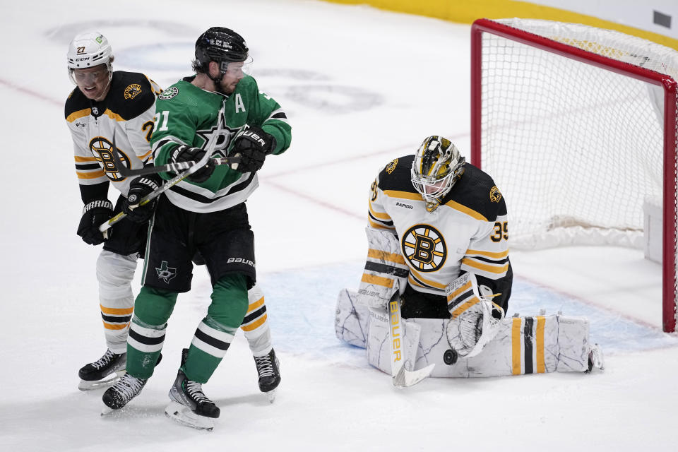 Boston Bruins goaltender Linus Ullmark (35) blocks a shot under pressure from Dallas Stars center Tyler Seguin (91) as Hampus Lindholm (27) helps defend on the play in overtime of an NHL hockey game, Tuesday, Feb. 14, 2023, in Dallas. (AP Photo/Tony Gutierrez)