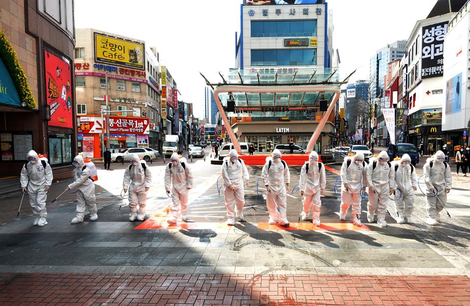South Korean army soldiers wearing protective suits spray disinfectant to prevent the spread of the COVID-19 virus on a street in Daegu, South Korea, Thursday, Feb. 27, 2020. As the worst-hit areas of Asia continued to struggle with a viral epidemic, with hundreds more cases reported Thursday in South Korea and China, worries about infection and containment spread across the globe. (Lee Moo-ryul/Newsis via AP)