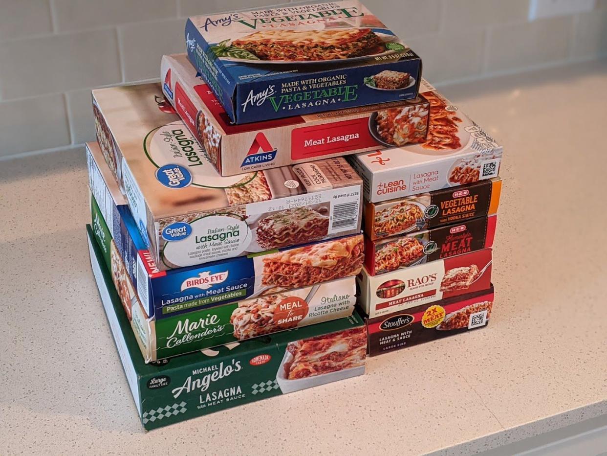 Ten boxes of frozen lasagna being reviewed including Great Value, HEB, Rao's, and more, on a sparkle beige countertop with beige tile on the wall in the background