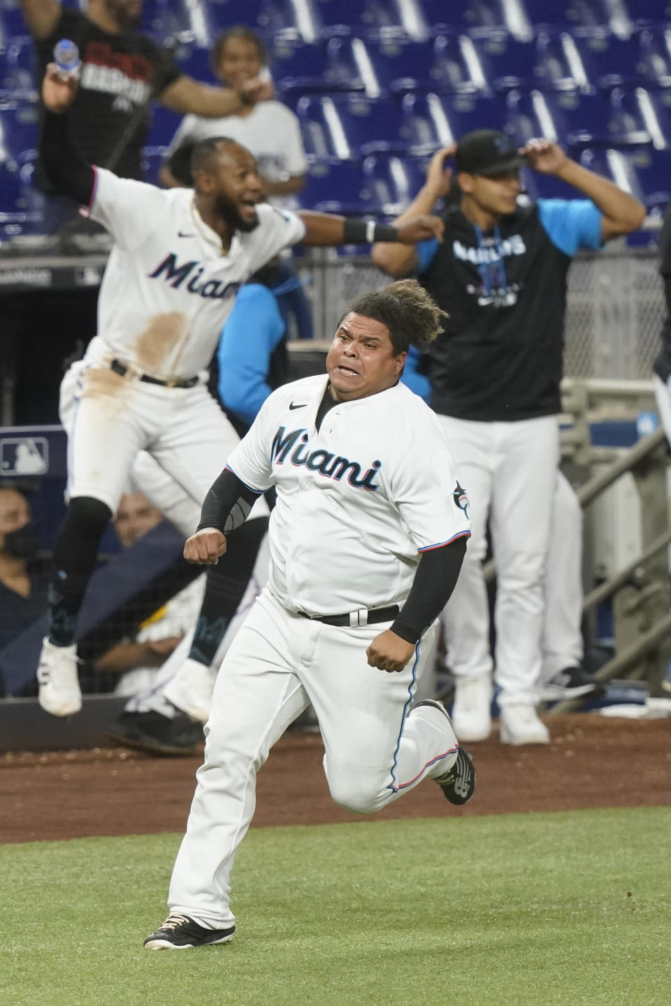 Miami Marlins Willians Astudillo (37) runs to score the winning run on a single by Jesus Aguilar in the tenth inning of a baseball game against the Washington Nationals, Wednesday, June 8, 2022, in Miami. The Marlins defeated the Nationals 2-1. (AP Photo/Marta Lavandier)