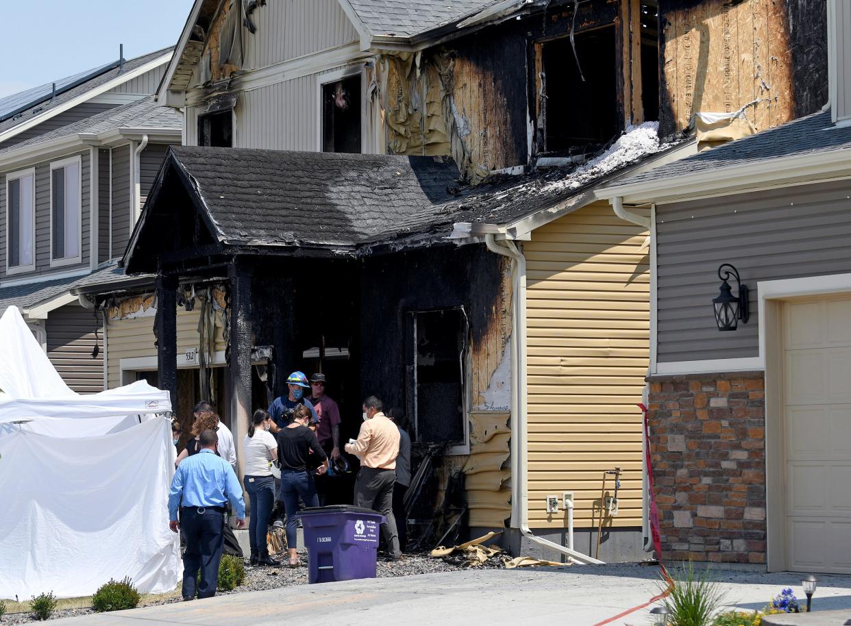 Investigators stand outside a house where five immigrants from Senegal were found dead after a fire in suburban Denver on Aug. 5, 2020