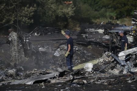 Members of the Ukrainian Emergencies Ministry work at the crash site of Malaysia Airlines Flight MH17 near the village of Hrabove, Donetsk region, July 20, 2014. . REUTERS/Maxim Zmeyev