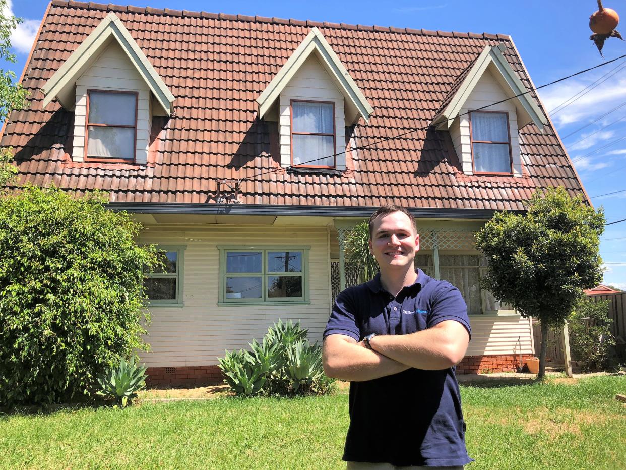 Eddie Dilleen in front of a recently renovated house that he purchased.