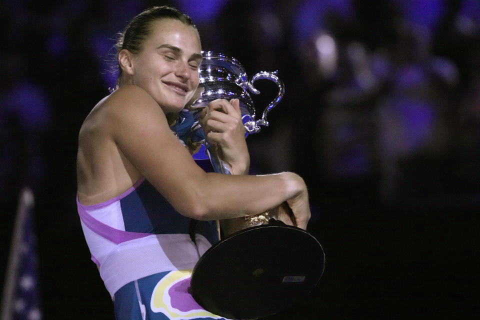 La bielorrusa Aryna Sabalenka abraza el trofeo Daphne Akhurst Memorial tras superar en la final del Abierto de Australia a Elena Rybakina el sábado 28 de enero del 2023. (AP Foto/Dita Alangkara)