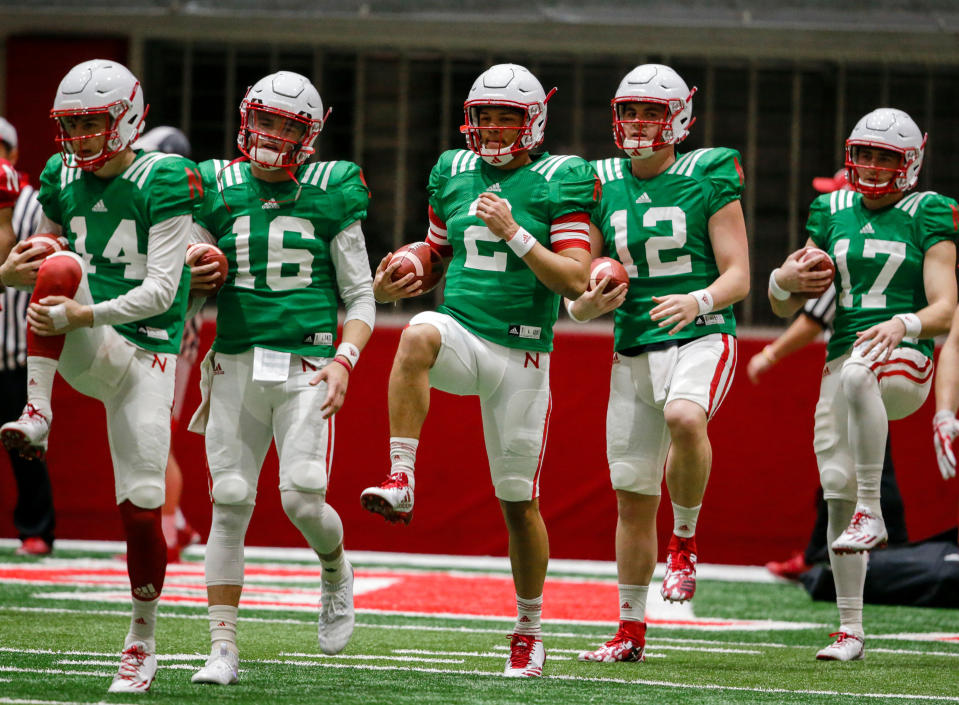 Nebraska quarterbacks Tristan Gebbia (14), Noah Vedral (16), Adrian Martinez (2), Patrick O’Brien (12) and Andrew Bunch (17), warm up during practice in Lincoln, Neb. (AP Photo/Nati Harnik)