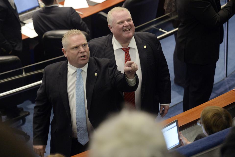 Toronto city councillor Doug Ford and his brother, Mayor Rob Ford react to the gallery after the mayor and an unidentified member of his staff captured images of the gallery during a special council meeting at City Hall in Toronto