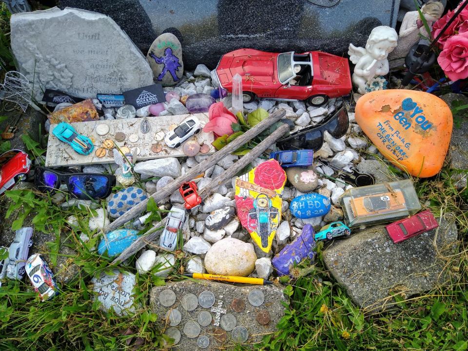 Cars fans have left personal items at the base of Benjamin Orr's headstone, including painted rocks, sunglasses, drumsticks, toy cars and coins.