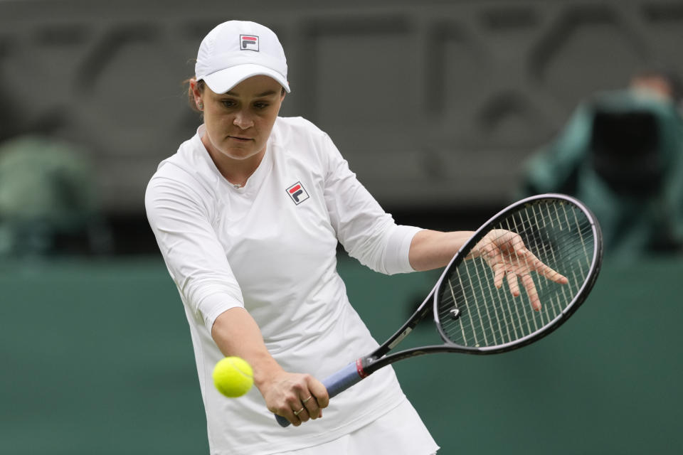 Australia's Ash Barty plays a backhand return during her invitation doubles match with compatriot Casey Dellacqua against Andrea Petkovic of Germany and Magdelena Rybarikova of Slovakia at the Wimbledon tennis championships in London, Wednesday, July 10, 2024. (AP Photo/Kirsty Wigglesworth)