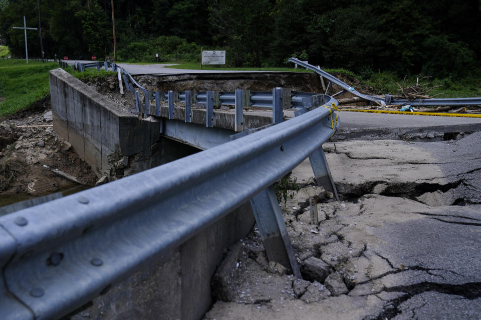 The road leading to a bridge above a creek cracks and breaks after massive flooding on Thursday, Aug. 4, 2022, in Chavies, Ky. (AP Photo/Brynn Anderson)